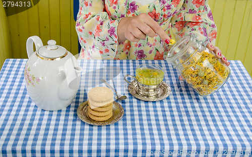 Image of hand prepare marigold herb tea 