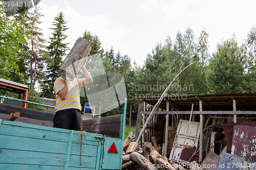 Image of worker man unload tree logs firewood from trailer 