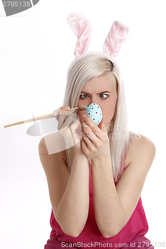 Image of Woman paints easter egg