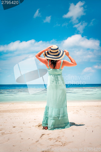 Image of Girl walking along a tropical beach in the Maldives.