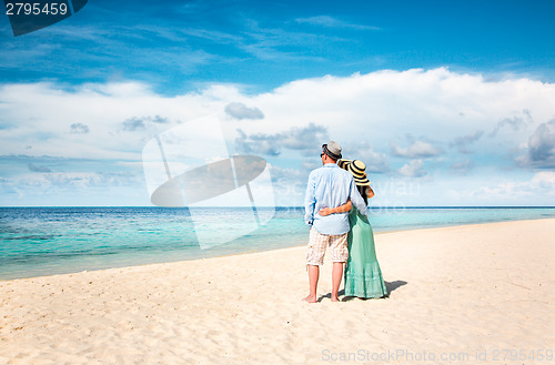 Image of Vacation Couple walking on tropical beach Maldives.