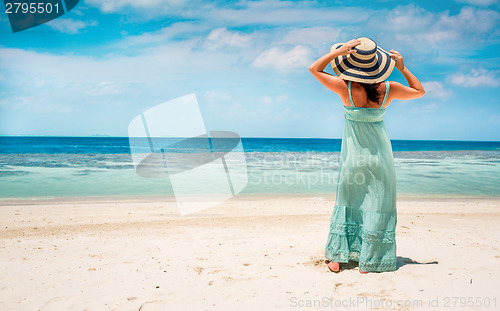 Image of Girl walking along a tropical beach in the Maldives.