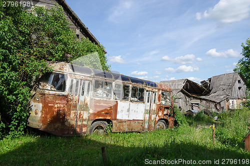 Image of rusty lonely broken bus in country green field  