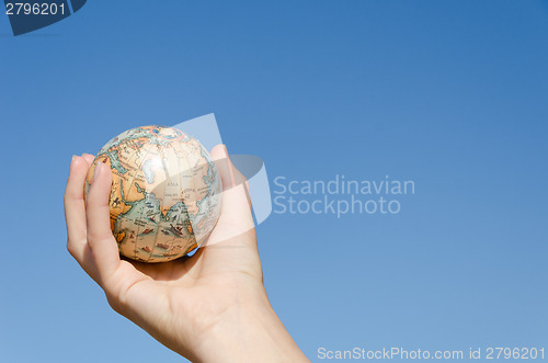 Image of global earth in hand on blue sky background, Asia  