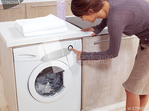 Image of putting a cloth into washing machine