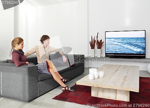 Image of couple sitting on the sofa watching tv ll