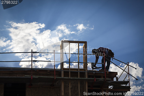 Image of Construction Worker Silhouette on Roof