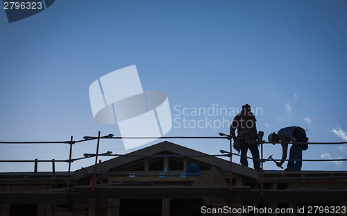 Image of Construction Workers Silhouette on Roof
