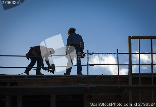 Image of Construction Workers Silhouette on Roof