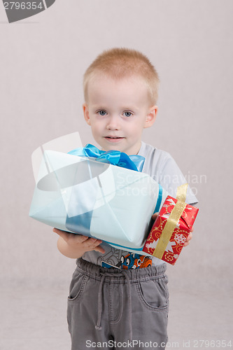 Image of boy stands with two gifts