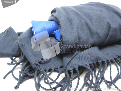 Image of Blue hot-water bag wrapped in a blue scarf with fringes 