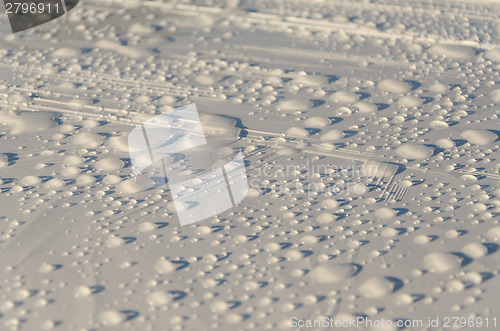 Image of rain drops glisten on white surface background 