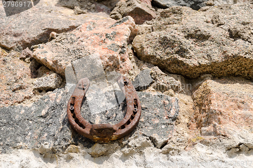 Image of old iron fortune symbol horseshoe on stone wall  