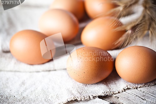 Image of  fresh brown eggs and wheat ears 