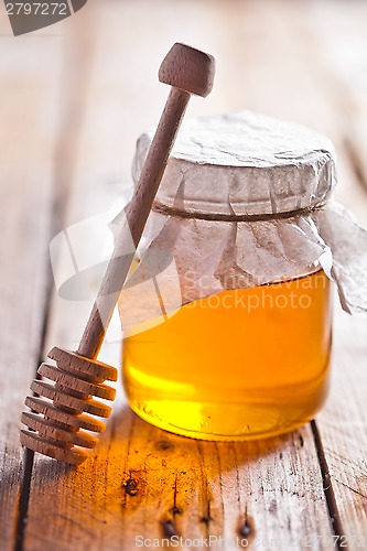 Image of full honey pot and honey stick 