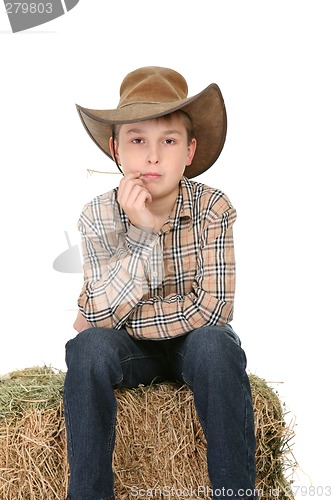 Image of Cowboy sitting on hay bale