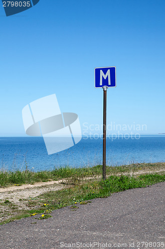 Image of European road sign passing place by a road along coastline