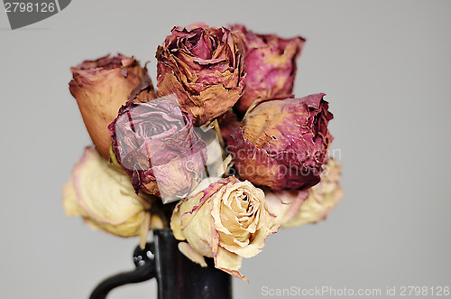 Image of bouquet of dried roses in ceramic vase