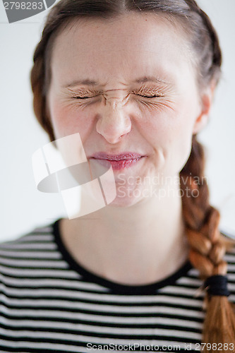 Image of Attractive woman smirking with eyes closed