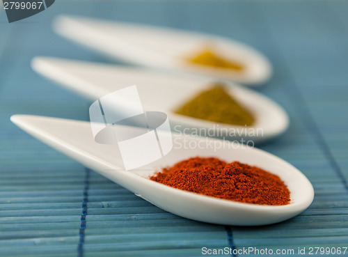 Image of Dried ground spices in ceramic spoons