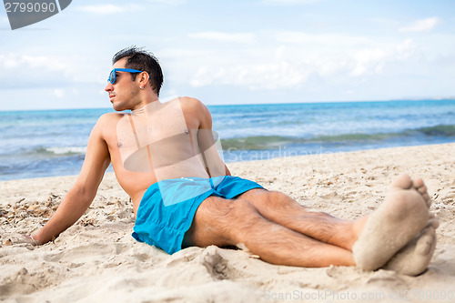 Image of Handsome man relaxing on the beach