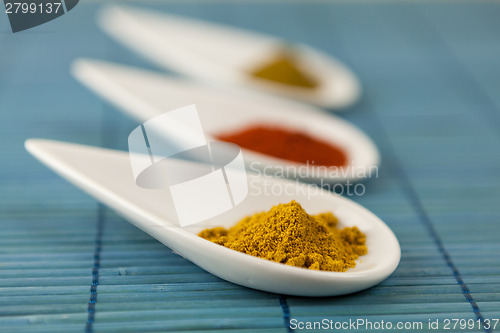 Image of Dried ground spices in ceramic spoons