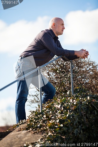 Image of Thoughtful man sitting on a flight of steps