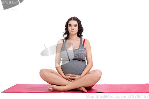 Image of Pregnant woman practising yoga and meditating