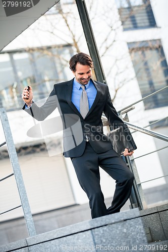 Image of Smiling businessman walking down stairs