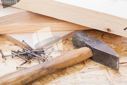 Image of Mallet with nails and planks of new wood