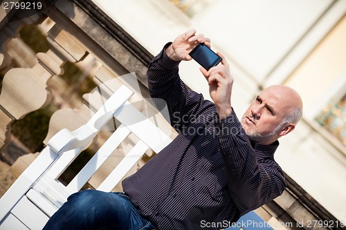 Image of Man taking a photograph with his mobile