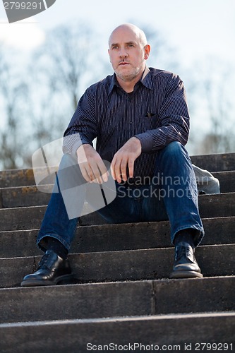 Image of Thoughtful man sitting on a flight of steps