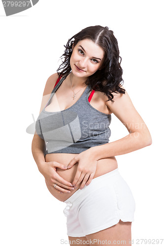 Image of Young pregnant woman making a heart gesture
