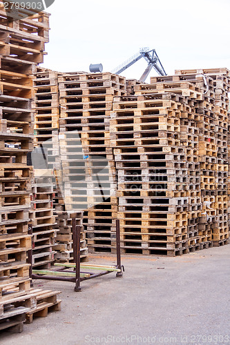 Image of Stacks of old wooden pallets in a yard