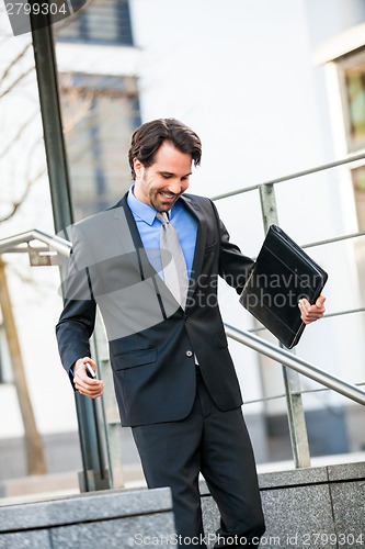 Image of Smiling businessman walking down stairs