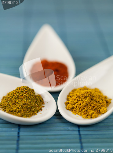 Image of Dried ground spices in ceramic spoons