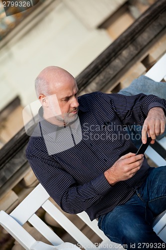 Image of Man checking a photo on his mobile phone
