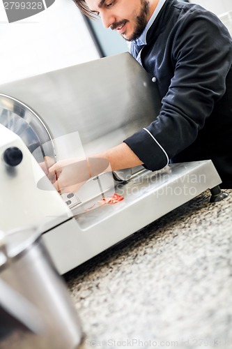 Image of Commercial cook or chef slicing cold meat