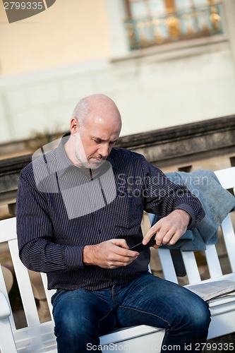 Image of Man checking a photo on his mobile phone