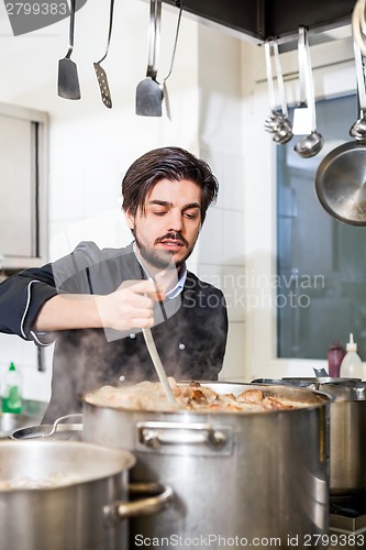 Image of Chef stirring a huge pot of stew or casserole