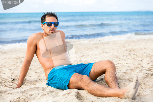 Image of Handsome man relaxing on the beach