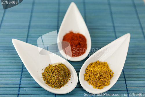 Image of Dried ground spices in ceramic spoons