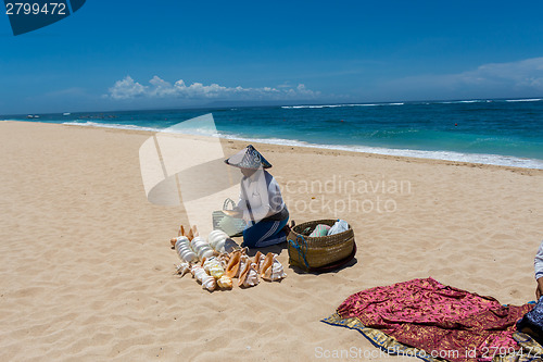 Image of Woman selling seashells on a beach in Bali