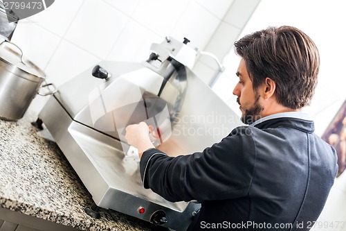 Image of Commercial cook or chef slicing cold meat