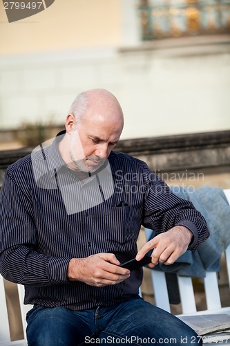 Image of Man checking a photo on his mobile phone