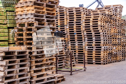 Image of Stacks of old wooden pallets in a yard