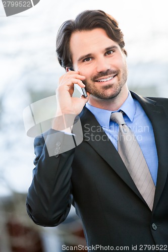 Image of Businessman listening to a call on his mobile