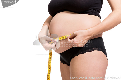 Image of Pregnant woman measuring her abdomen