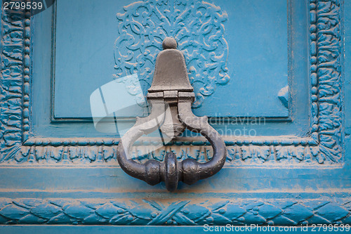 Image of Brass door handle on a colorful blue door