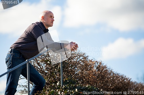 Image of Thoughtful man sitting on a flight of steps